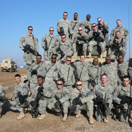 U.S. Army soldiers in uniform with military vehicles in the background, symbolizing the importance of veteran support.